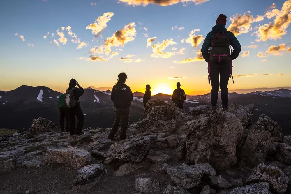 Hikers stare into sunset