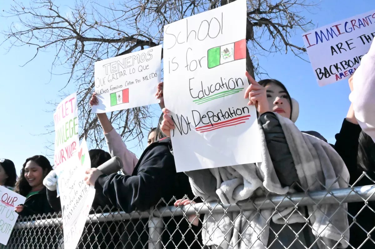 Teenage protesters hold up a sign.