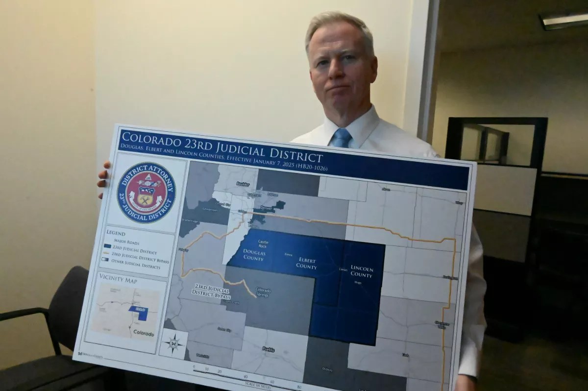 George Brauchler holds up a map.