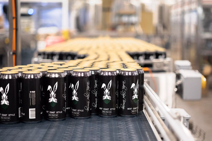 Cans of beer with dark label and rabbit.