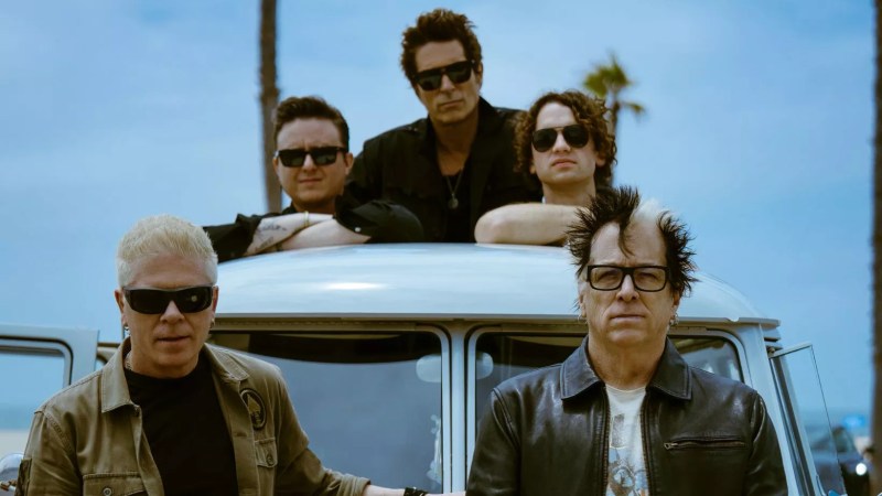 Members of The Offspring pose on a car