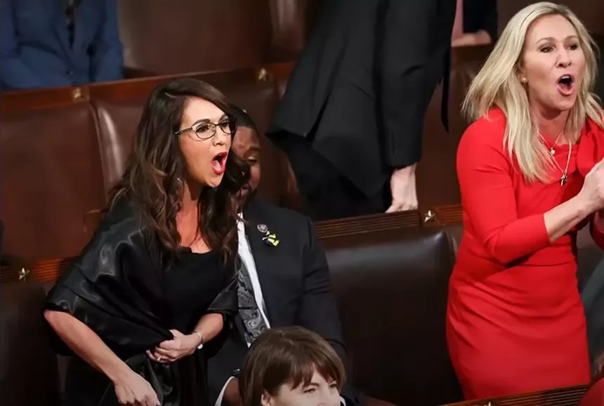 woman in red and women in black yelling