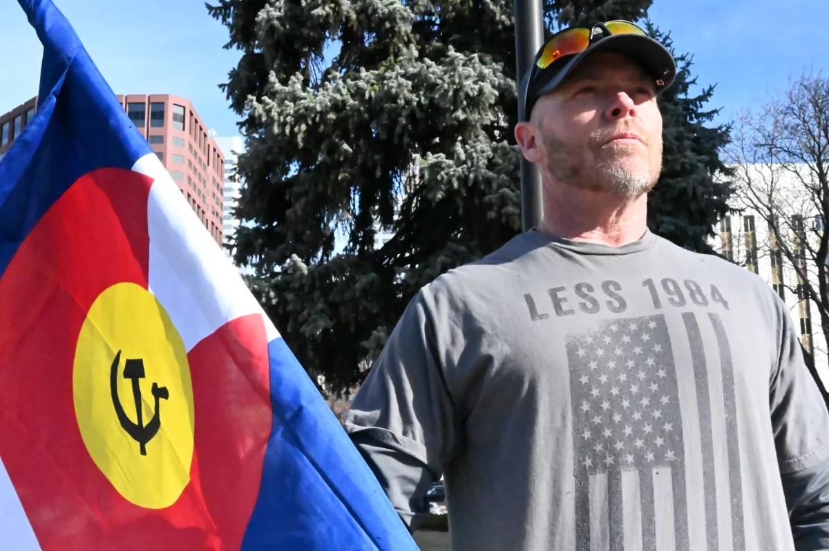 A man holds up a flag.