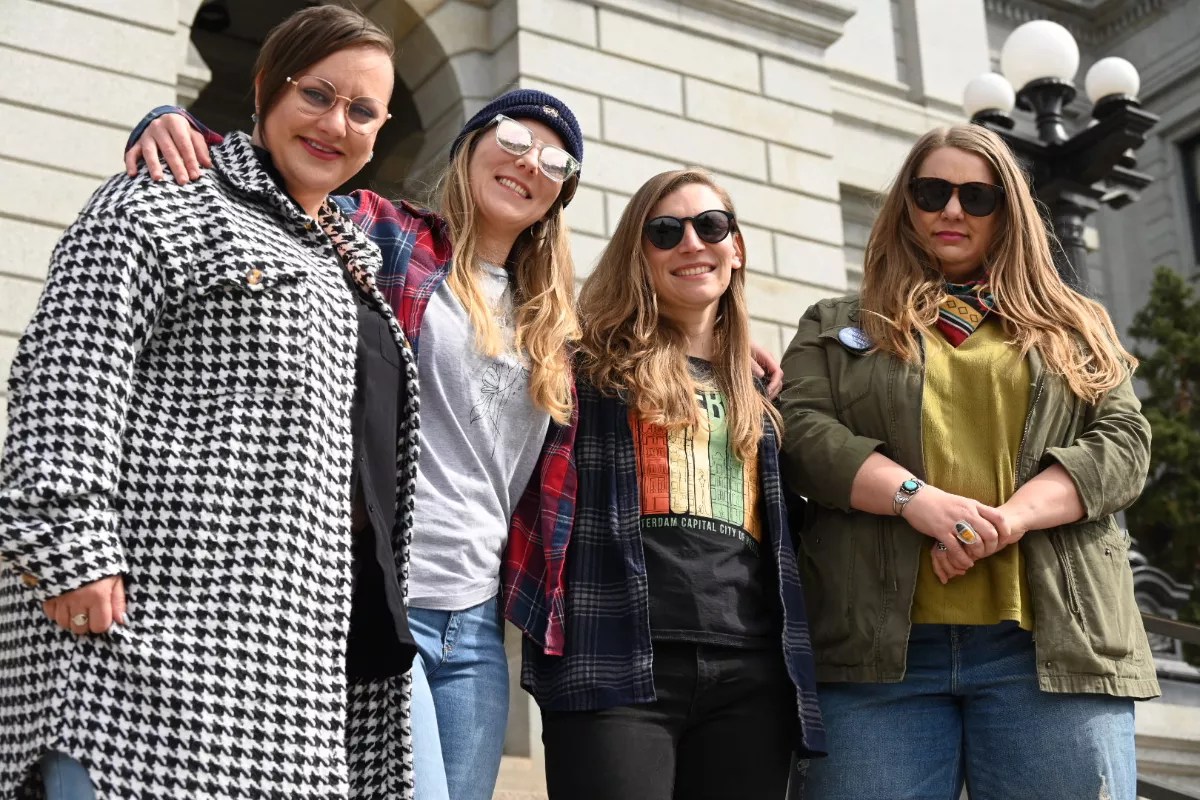 Women smile and look at the camera.