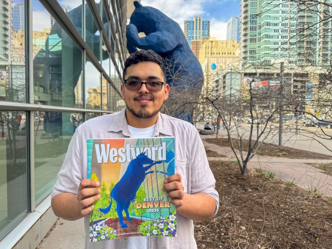 man holding paper by big blue bear