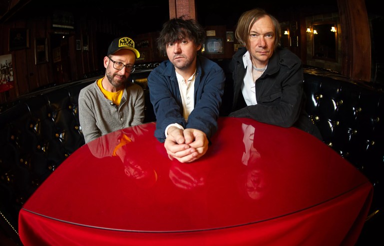 Bright Eyes' Mike Mogis, Conor Oberst, Nate Walcott are pictured sitting at a red table