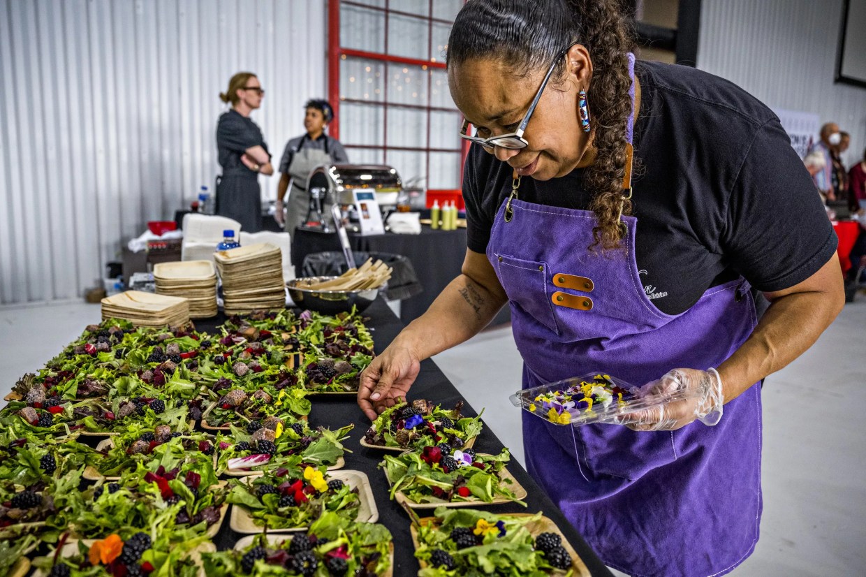 A chef plating multiple salad dishes at Denver EATSS
