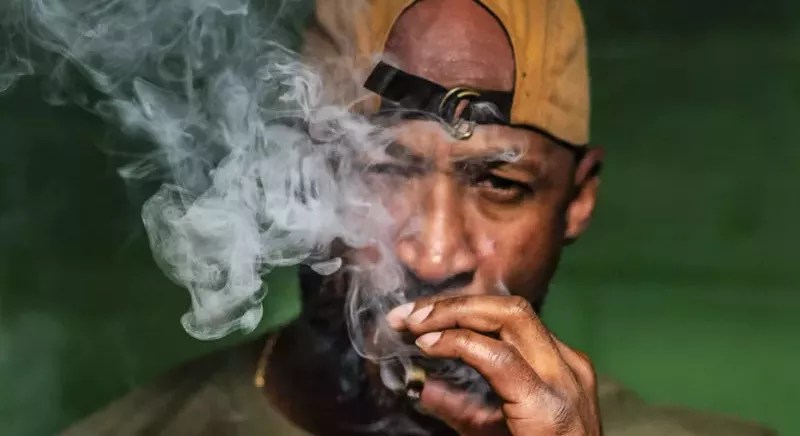 man in hat smoking joint