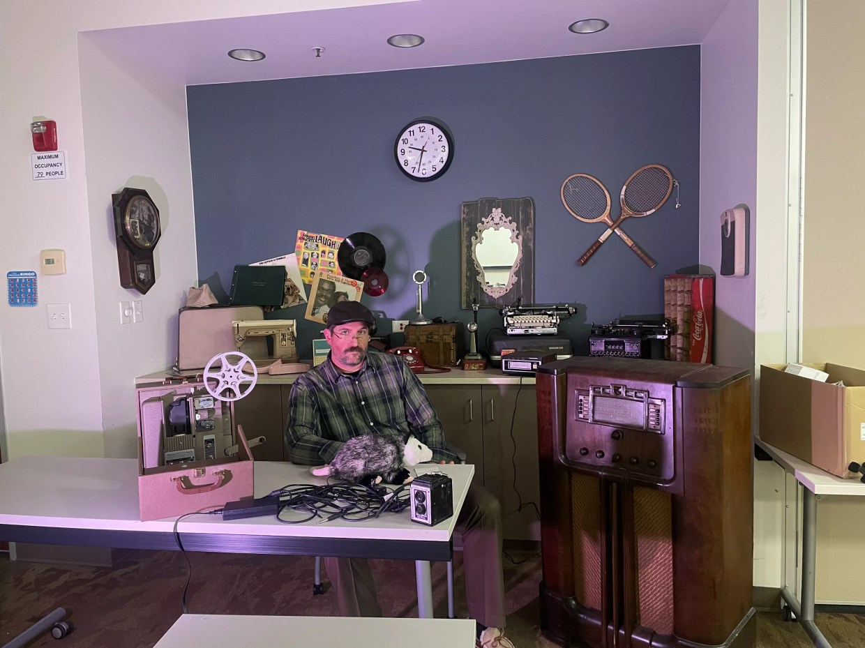 Man sits around retro technology.