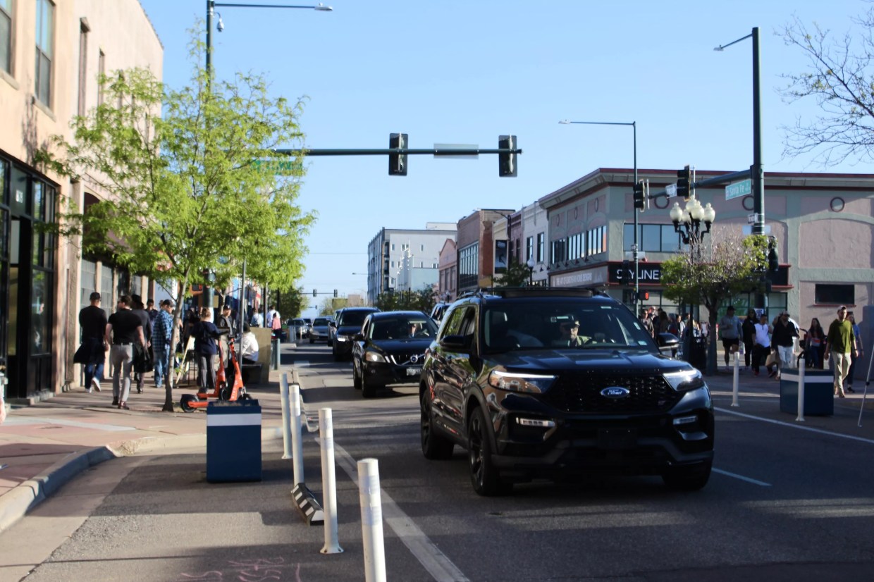 Cars drive down a busy street