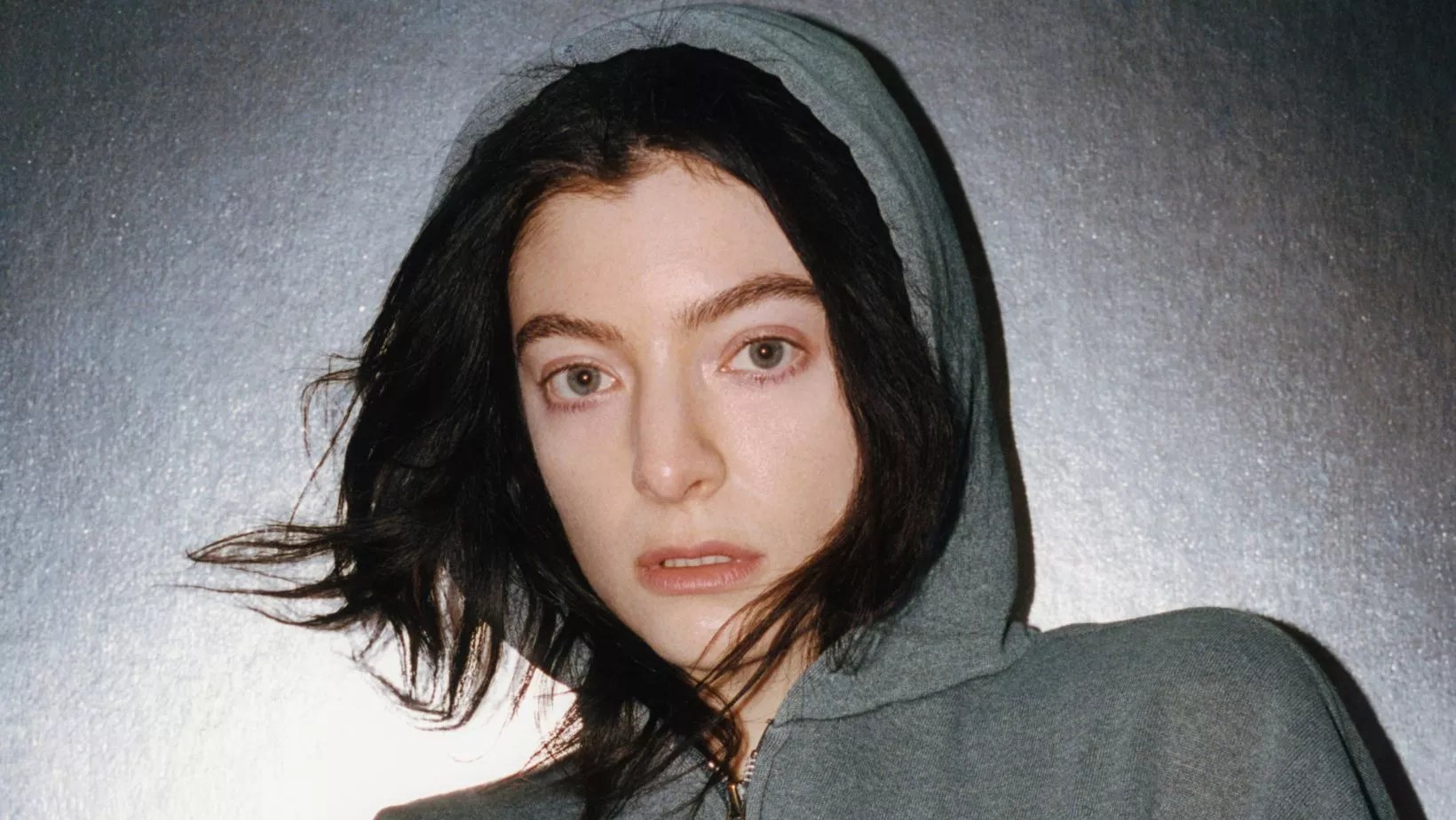 the singer Lorde in a grey sweatshirt