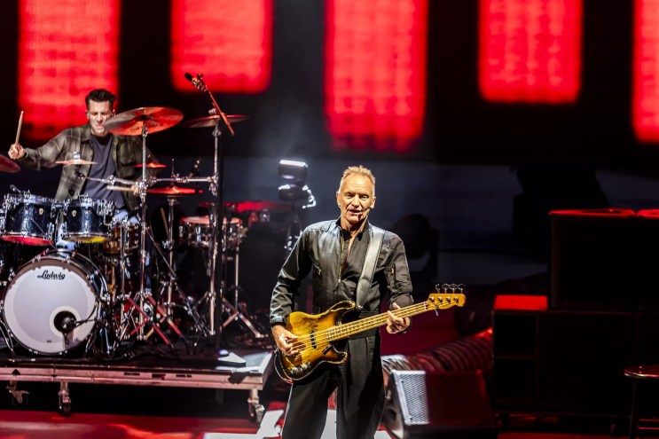 Sting on stage at Red Rocks with his band behind him.