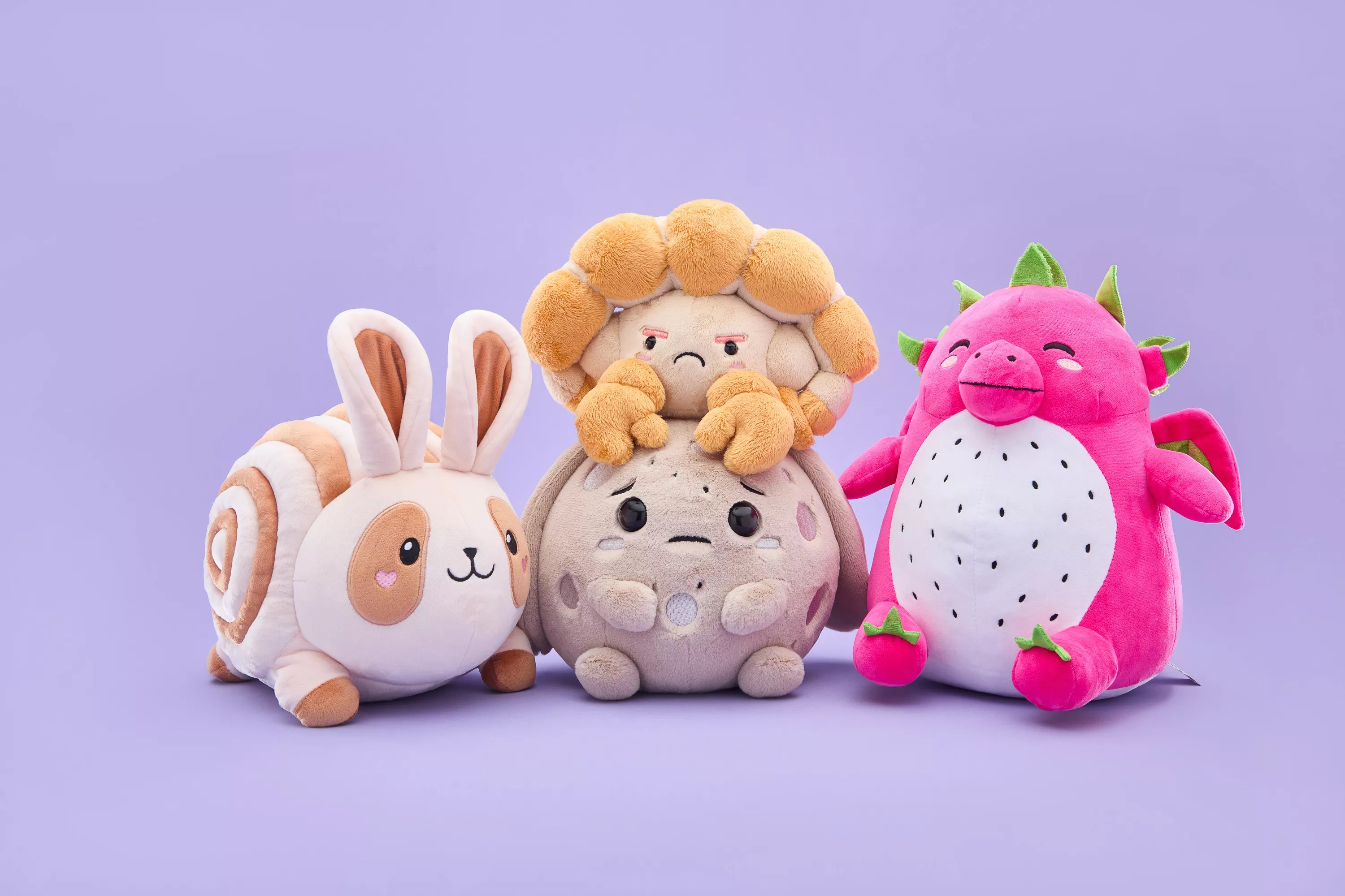 Four cute food and space-themed plush toys have a distinct emotion on their face.