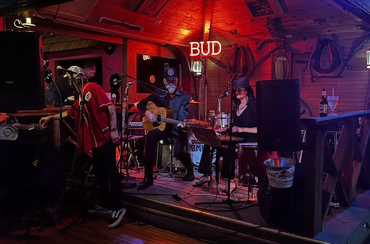 band performing on stage with red and purple lighting
