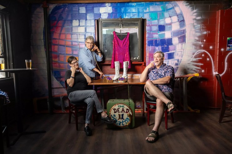 People sit in front of a disco ball mural