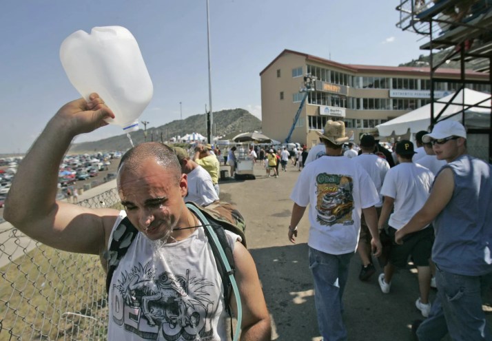 man pours water over his head on a hot summer day