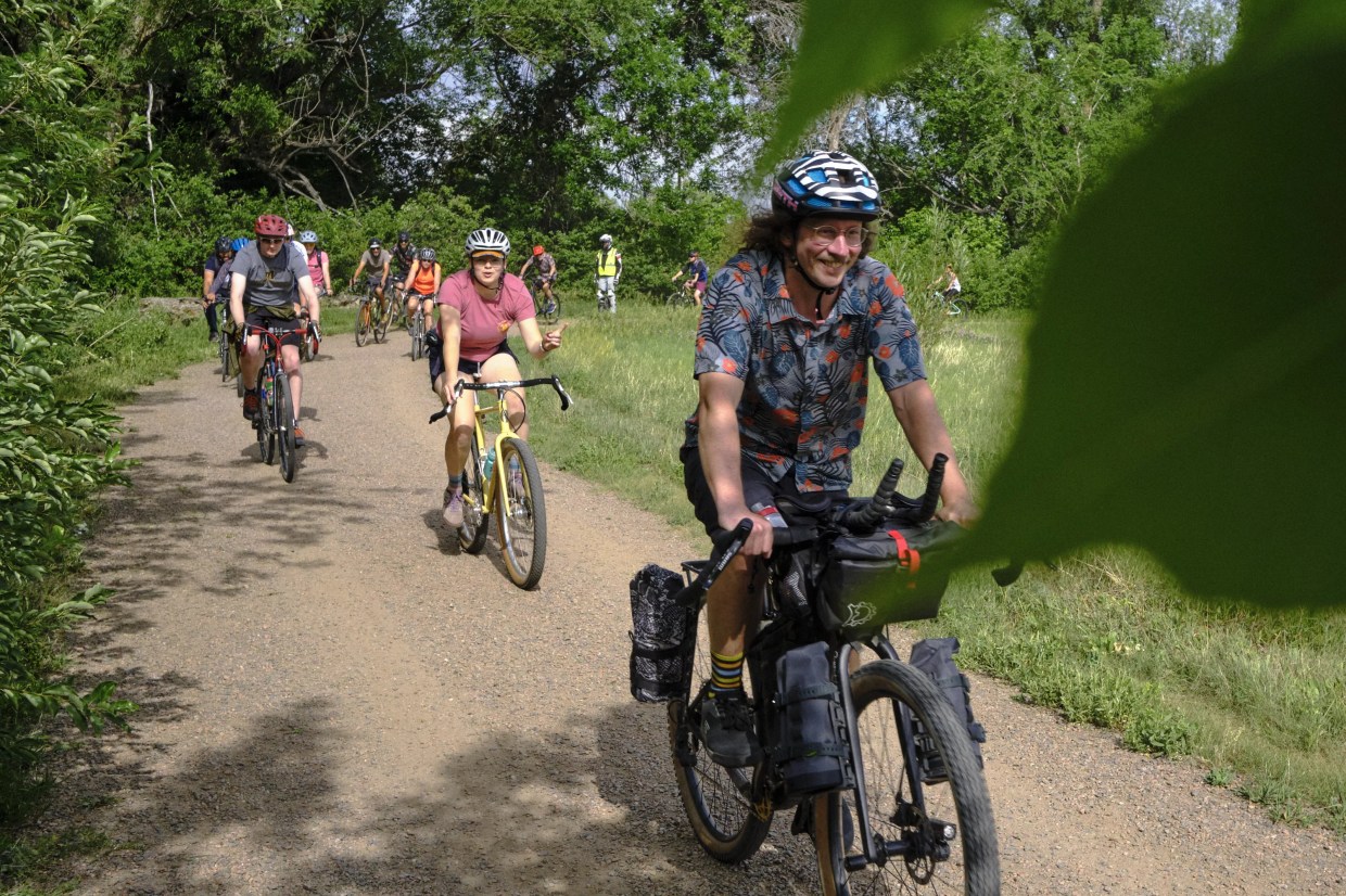 Several bikers on a forested gravel path in Boulder