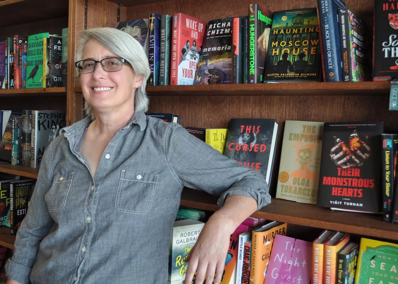 A woman next to bookshelves