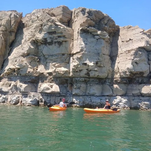 People kayak in a lake with mountains