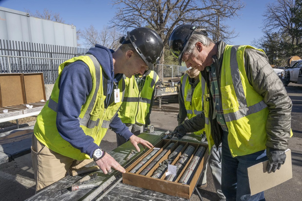 People in yellow vests examine specimen