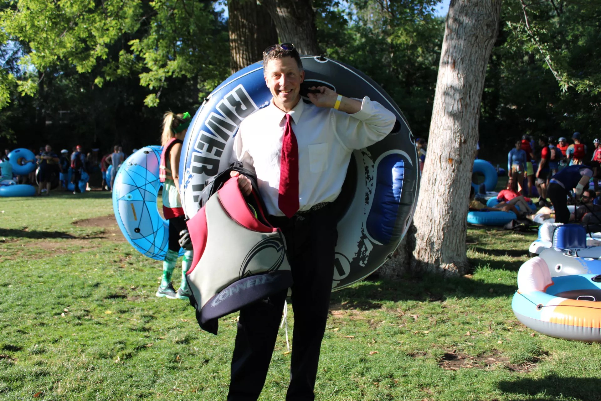 A man in a suit poses with an inner tube
