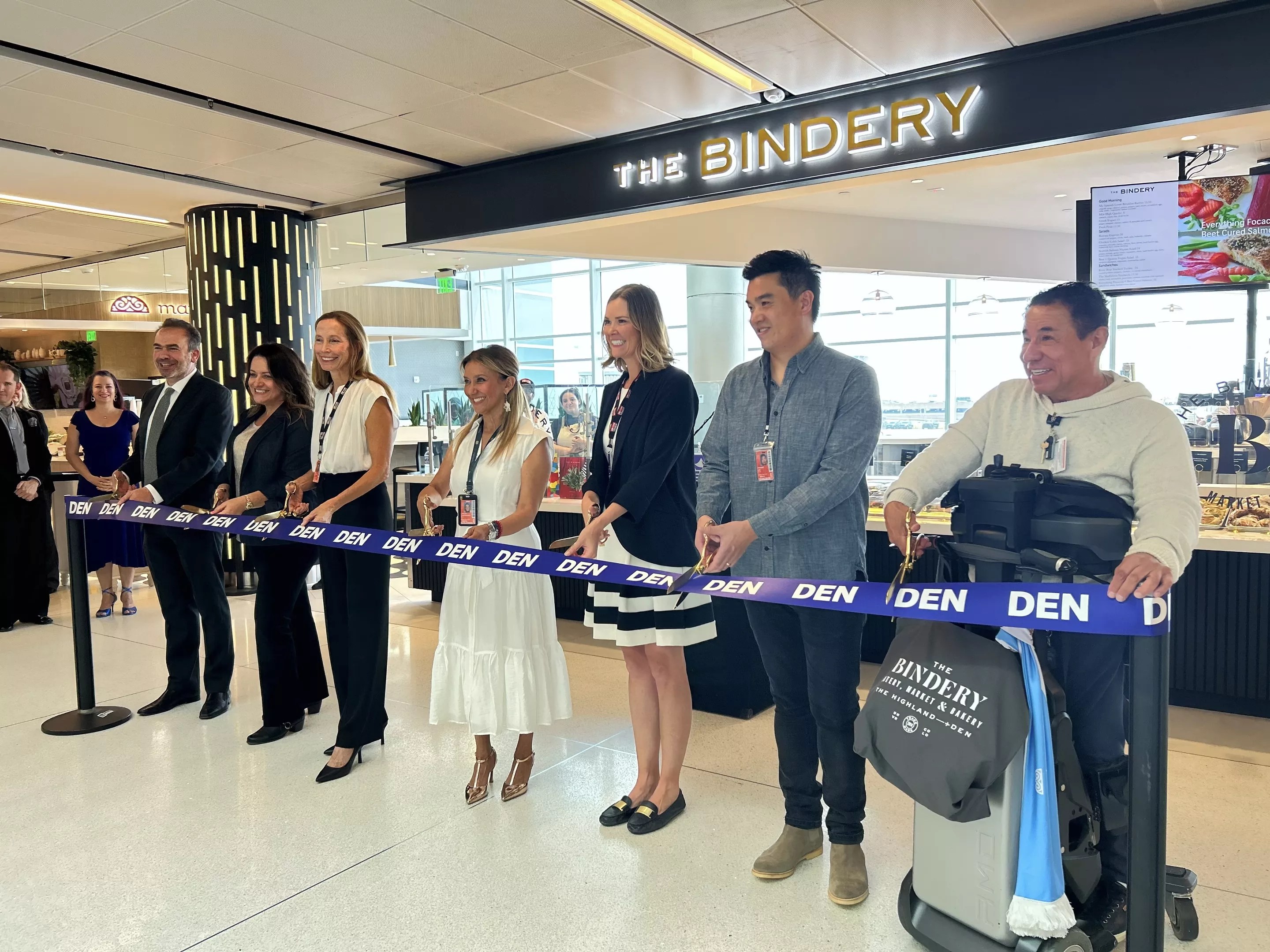 Restaurant owners and airport representatives readying to cut the grand opening ribbon