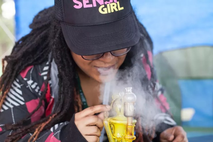 woman takes dab hit of marijuana hash