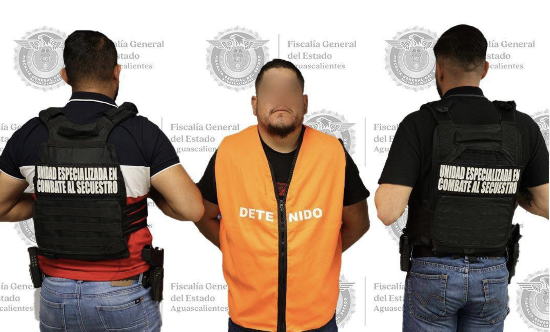 A man in an orange vest faces the camera as two men with their backs turn are beside him.