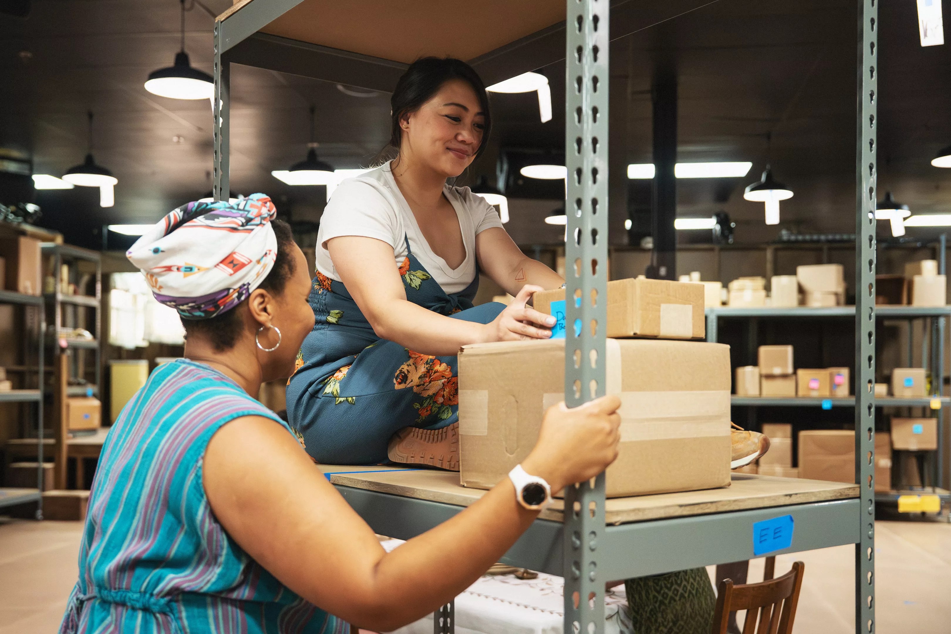 People interact with a shelf of boxes