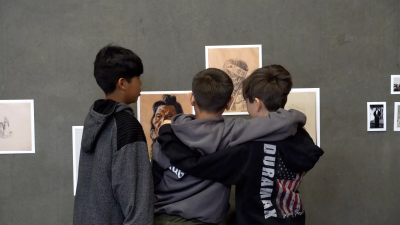 Kids gather around art.